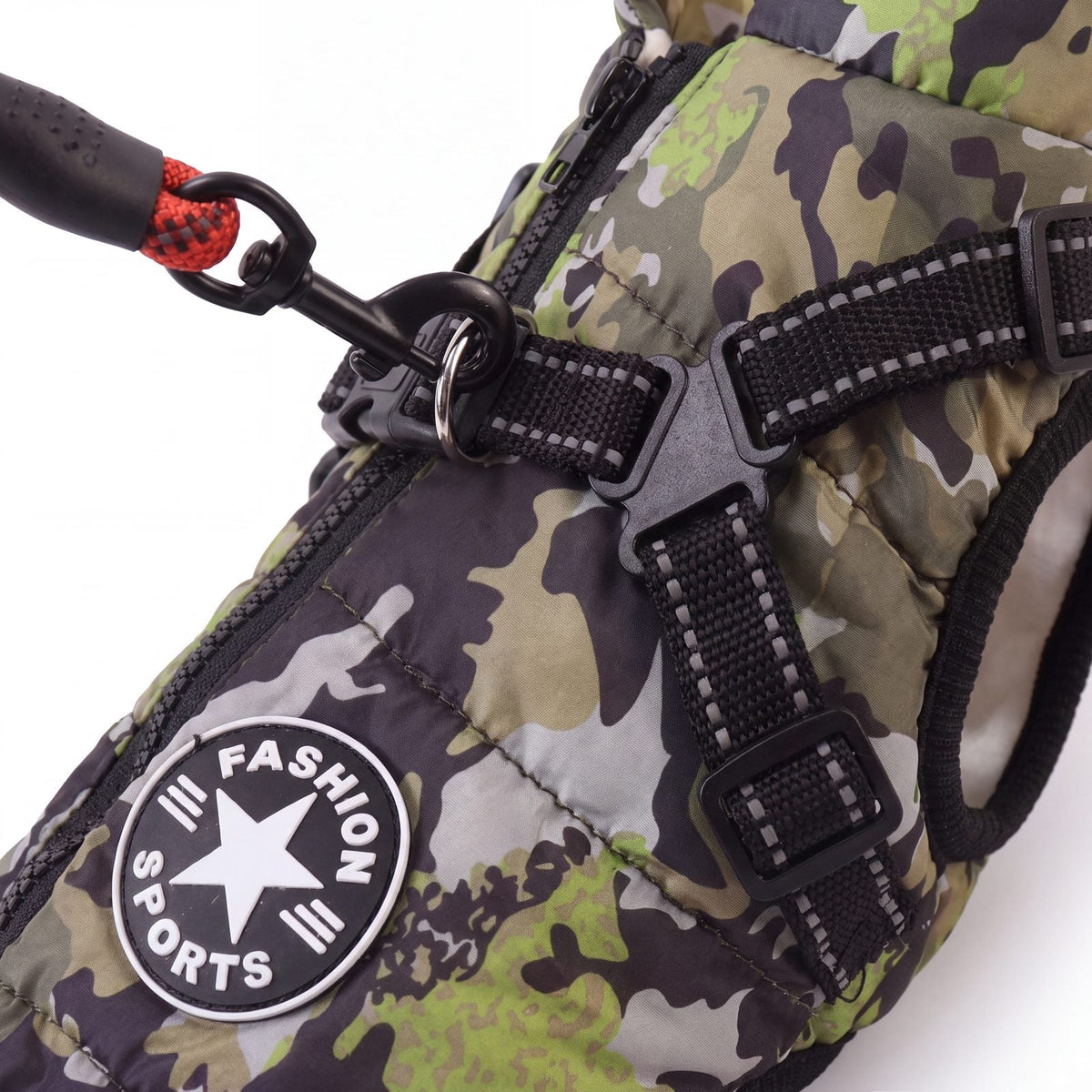 Mousqueton d'une laisse clipsé sur l'anneau en D du harnais intégré du manteau camouflage pour chien
