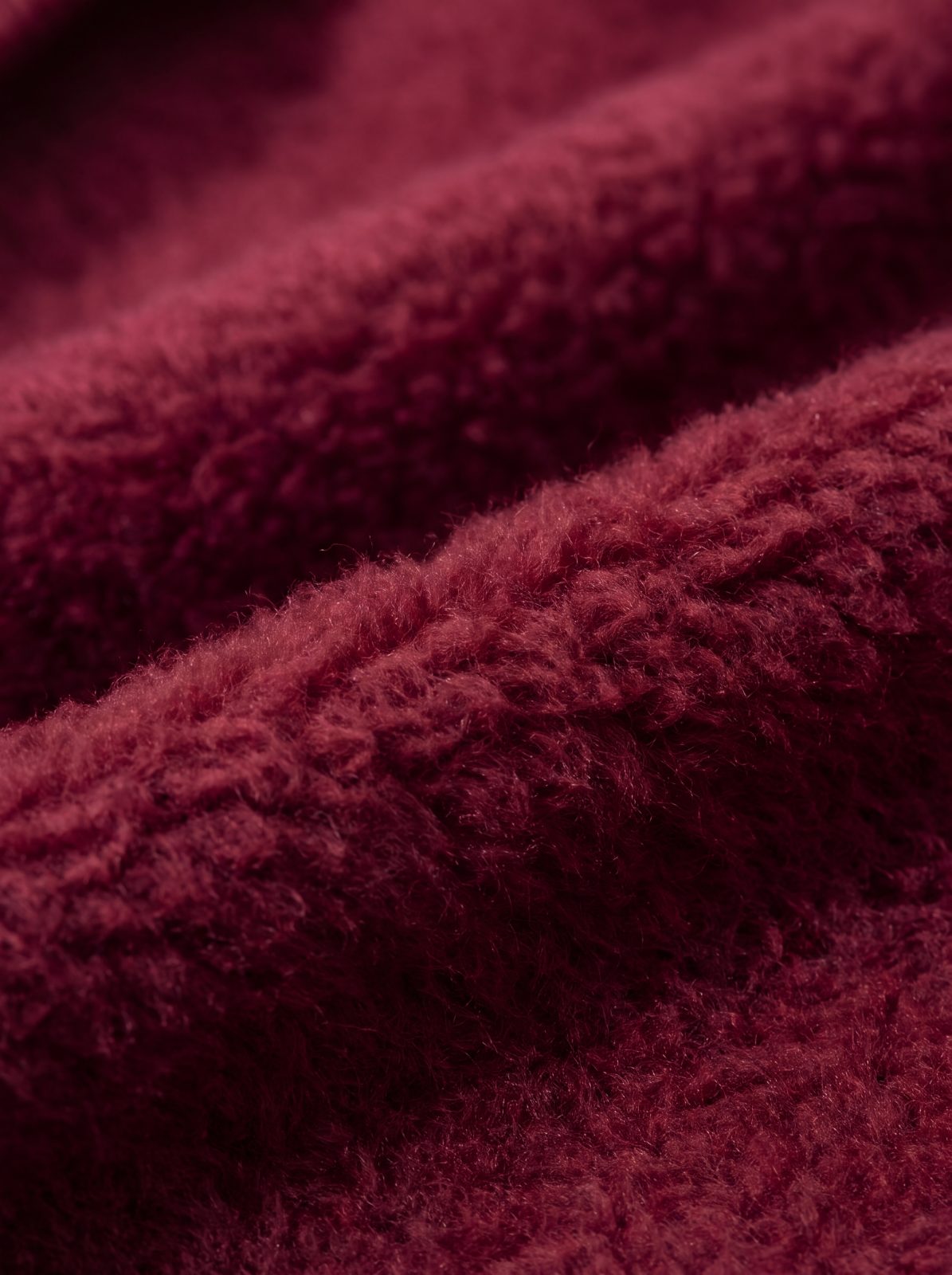 Gros plan sur la doublure polaire douce du sweat à capuche chien bordeaux