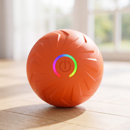 Balle pour chien rebondissante intelligente orange avec bouton lumineux, gros plan sur parquet