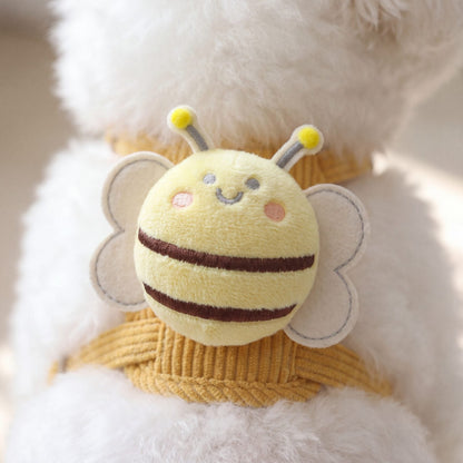 Gros plan sur l'abeille en peluche du harnais petit chien jaune, avec ses rayures marron, ses ailes crème et ses antennes à pompons jaunes