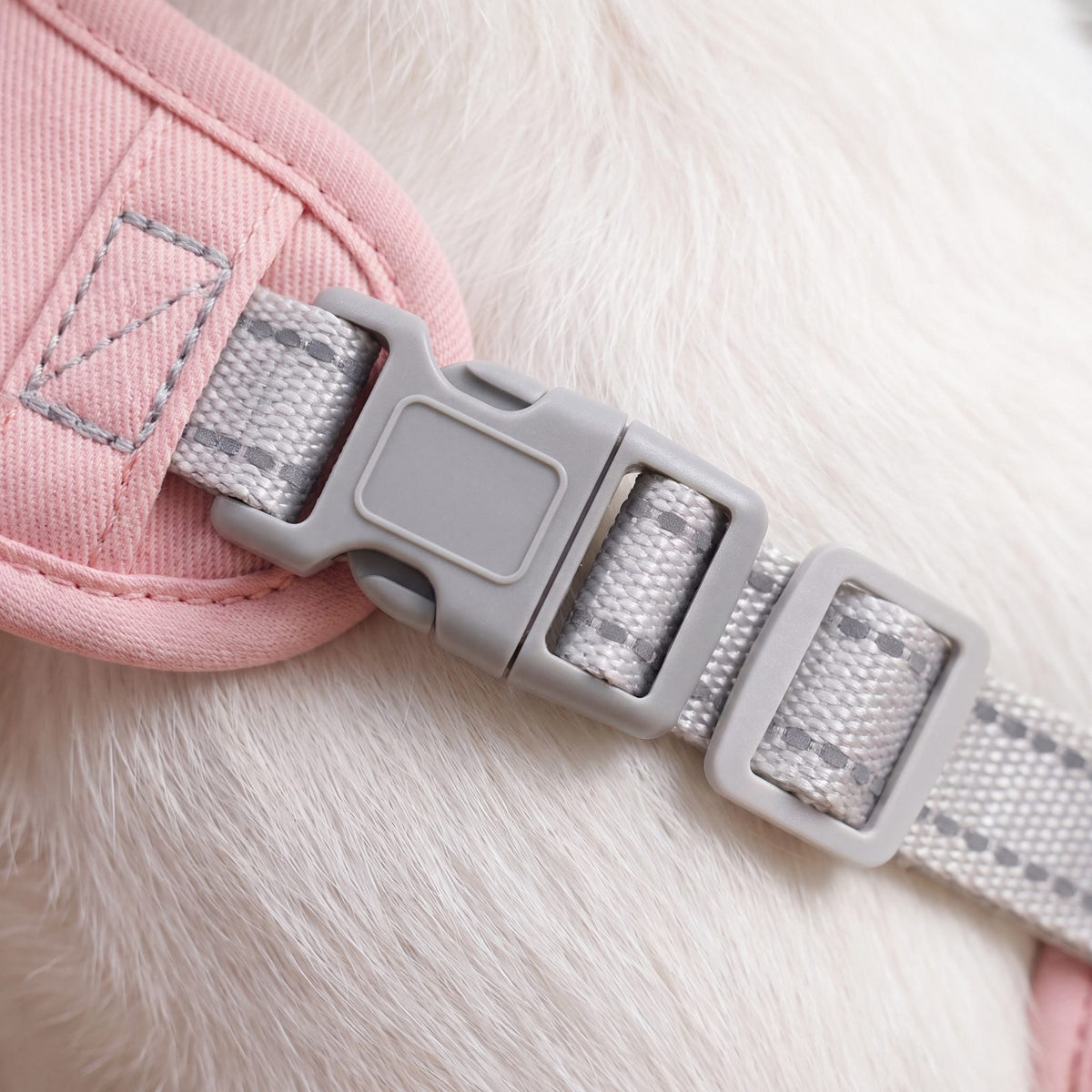 Macro de la boucle grise et du curseur de réglage du harnais croisé rose en sergé