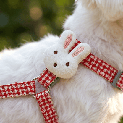 Gros plan macro sur le pompon lapin en peluche du harnais petit chien LapinChou rouge à carreaux vichy, fixé sur le côté