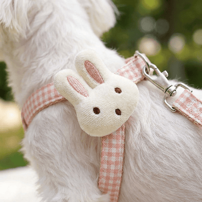 Gros plan macro sur le pompon lapin en peluche du harnais petit chien LapinChou rose à carreaux vichy, fixé sur le côté