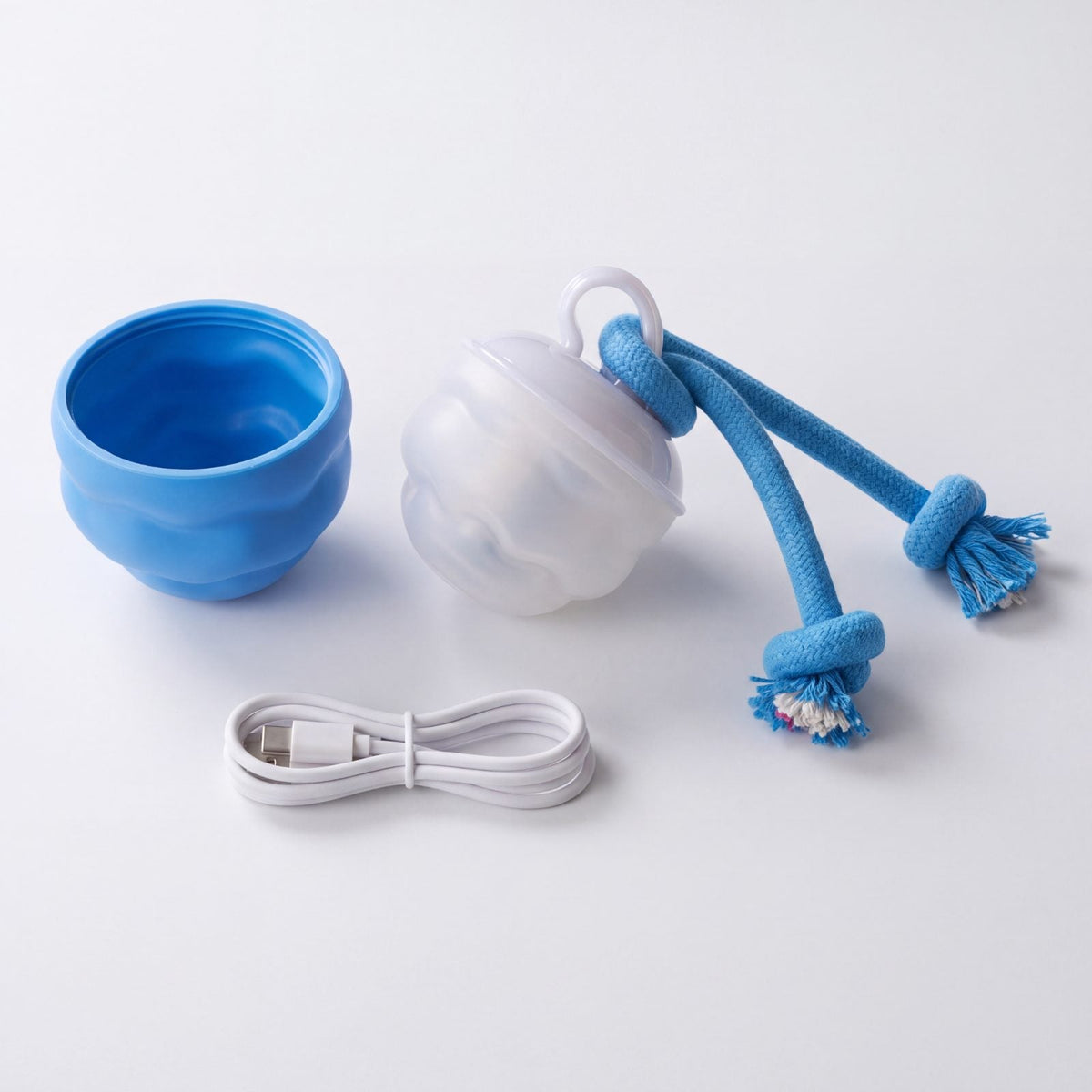 Coque bleue dévissée, cœur blanc de la balle avec sa corde et câble de recharge USB-C