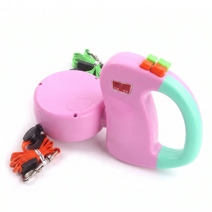 Laisse double rétractable pour deux chiens DuoChic rose pastel avec sangles verte et orange et mousquetons.