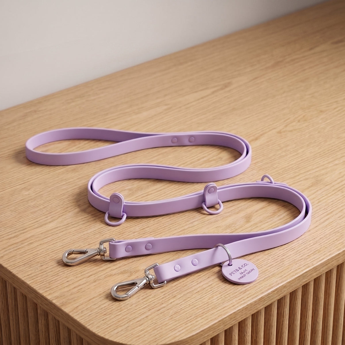 Laisse pour chien main libre multi-tâches en PVC violet, présentée à plat sur fond bois