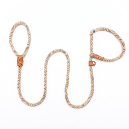 Laisse corde pour chien CaninoFlex modèle lasso beige clair tressé avec boucle de réglage et finitions en cuir naturel posée sur une table en bois en intérieur chaleureux