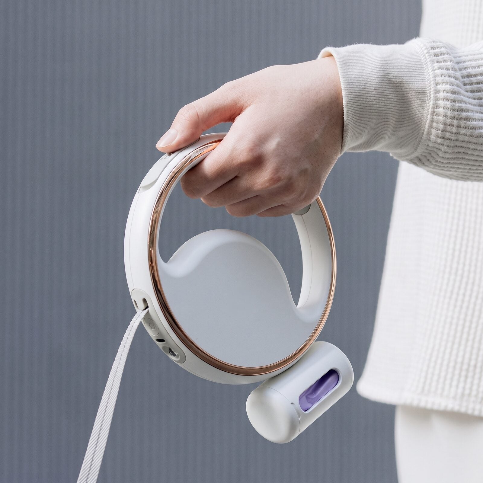 Gros plan sur la poignée et le distributeur de sacs de la laisse enrouleur rechargeable pour chien GlowLoop