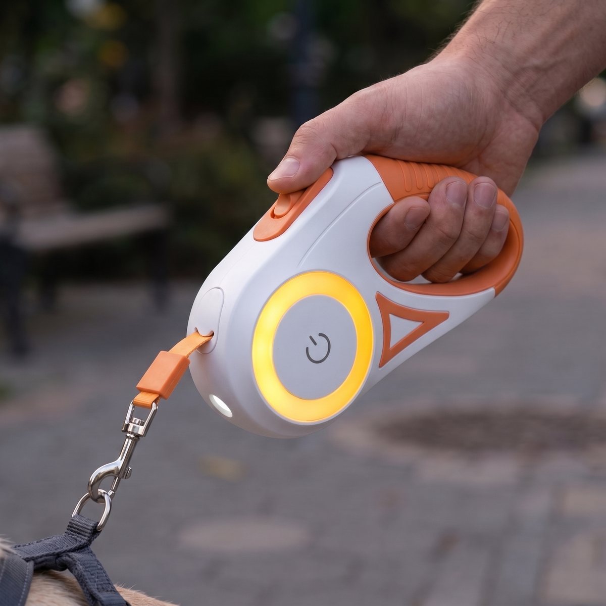 Laisse pour chien LiteWalk coloris orange, macro de la poignée avec torche LED allumée dans un parc