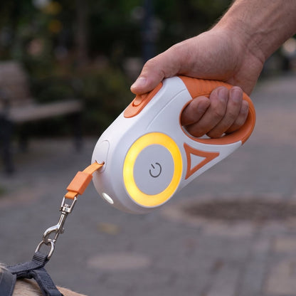 Laisse pour chien LiteWalk coloris orange, macro de la poignée avec torche LED allumée dans un parc