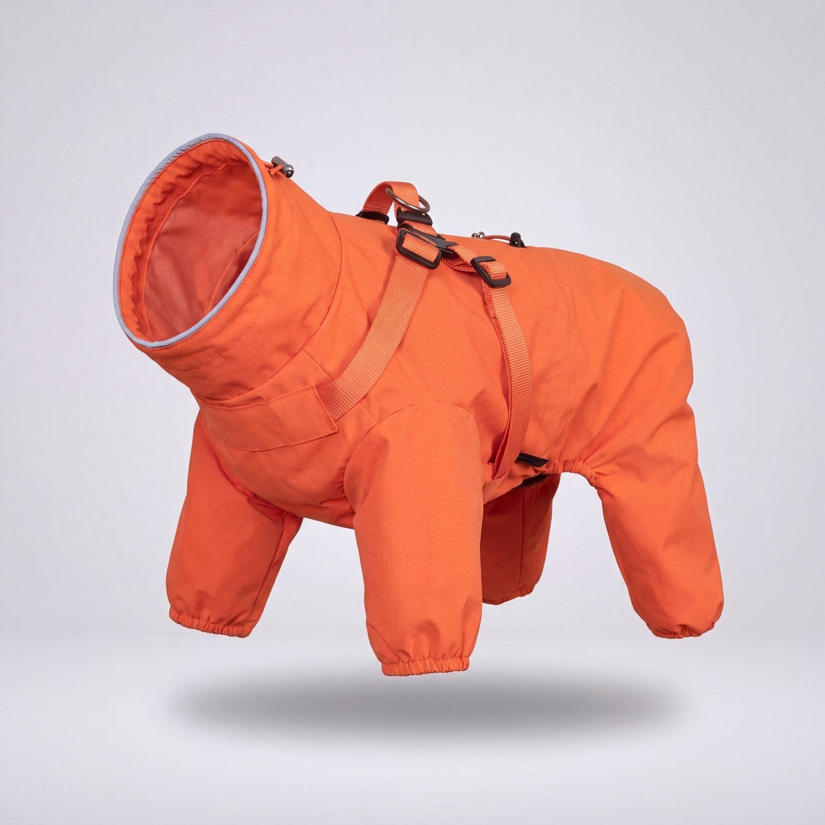 Manteau orange imperméable pour chien avec harnais intégré, présenté seul sur fond clair en vue trois quarts