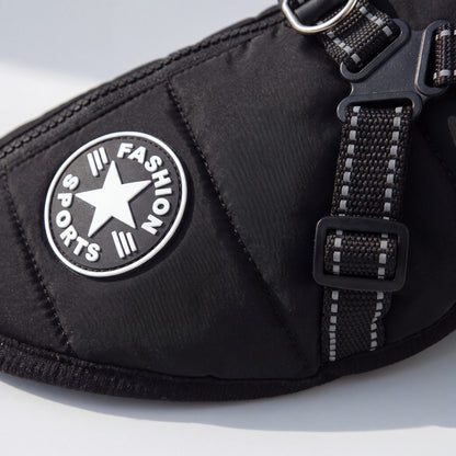 Gros plan sur l'écusson rond Fashion Sports et la sangle réfléchissante du manteau pour chien noir