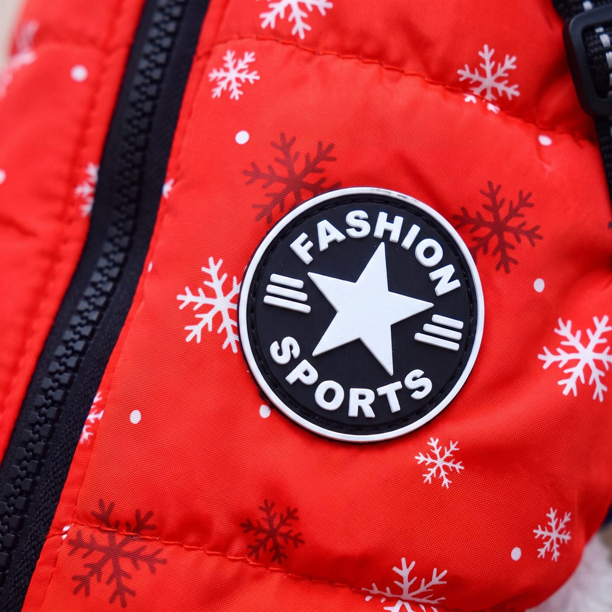 Écusson rond noir et blanc en forme d'étoile sur le manteau rouge vif à flocons pour chien