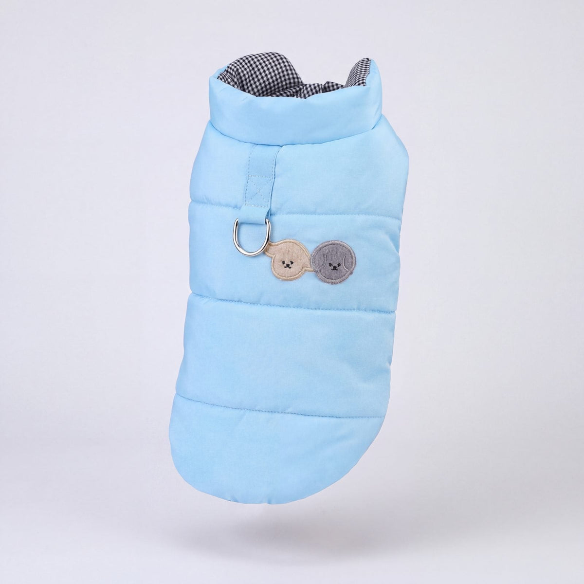 Doudoune bleu ciel matelassée pour chien avec harnais intégré, présentée seule sur fond gris clair
