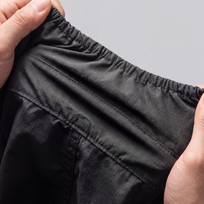 Vue de l'intérieur du manteau pour chien : tissu ripstop, coutures renforcées et manchette élastique, tenus à deux mains