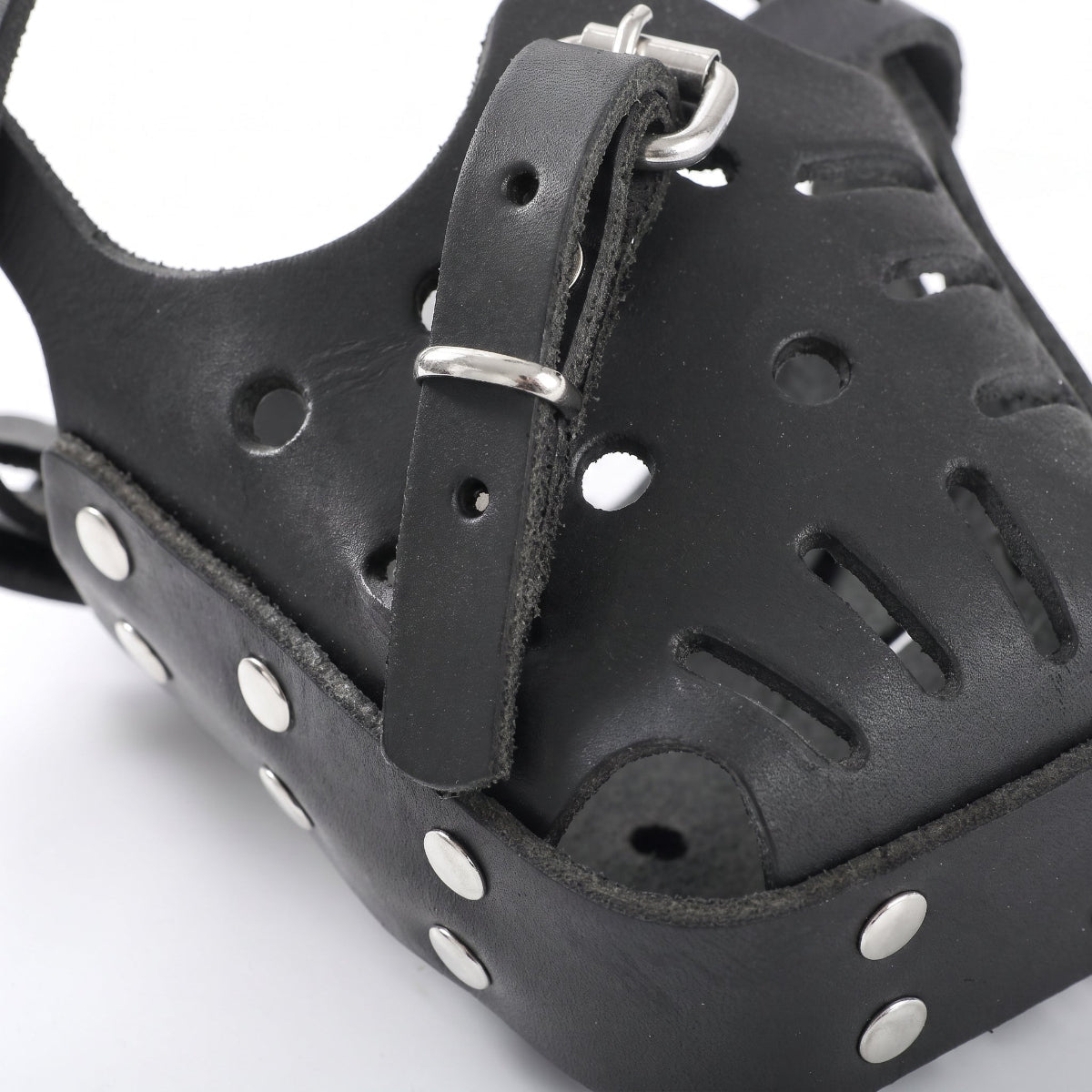Gros plan sur les finitions, trous d'aération, rivets solides et boucle en métal de la muselière MuzoSteel.