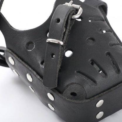Gros plan sur les finitions, trous d'aération, rivets solides et boucle en métal de la muselière MuzoSteel.