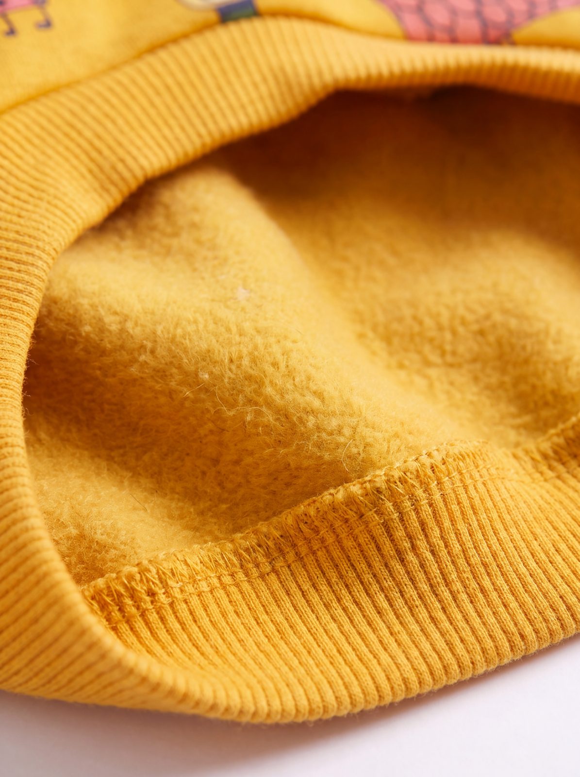Gros plan sur la doublure polaire douce du pull chien jaune