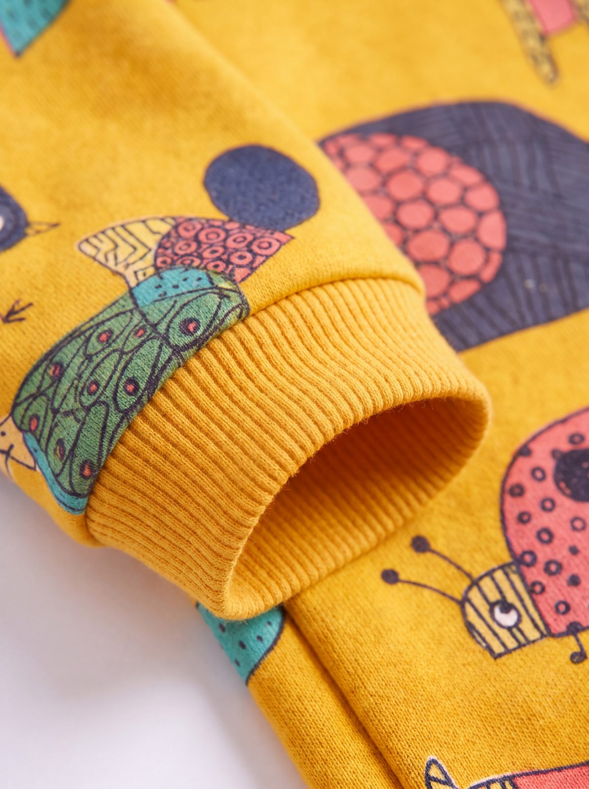 Gros plan sur le poignet côtelé du pull chien jaune à motif d'animaux