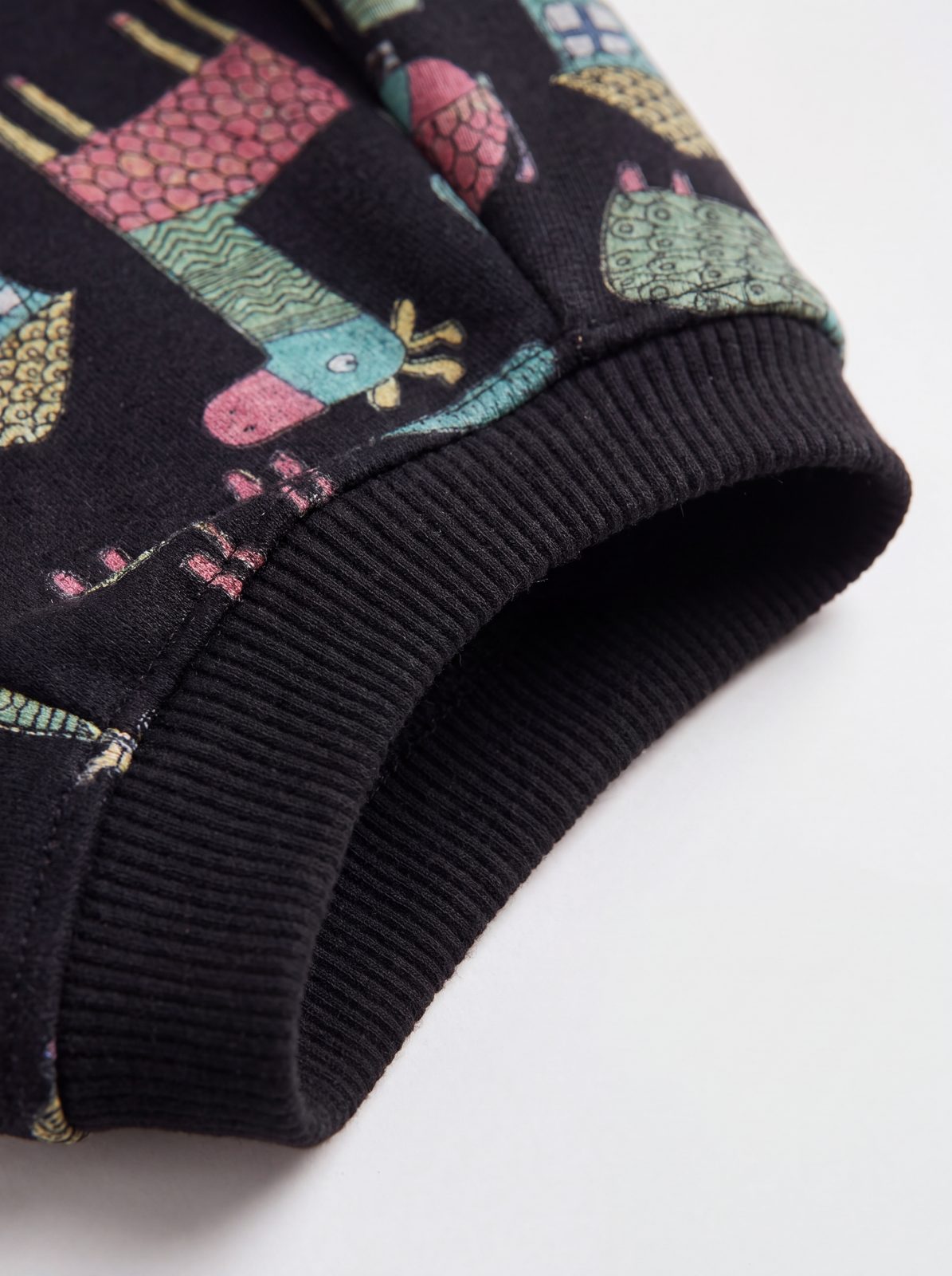 Zoom sur le poignet côtelé noir du pull chien doublé polaire à motif d'animaux