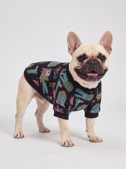 Bouledogue français souriant en trois quarts avec un pull chien noir doublé polaire à imprimé d'animaux et de maisons