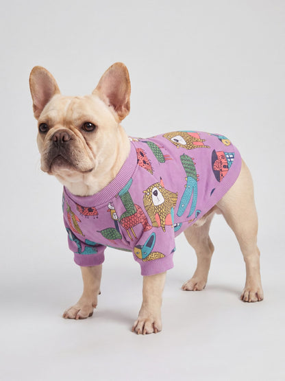 Bouledogue français vu de trois quarts en studio avec un pull chien violet doublé polaire à motif d'animaux colorés