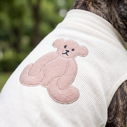Gros plan sur le grand ourson appliqué dans le dos du pull blanc crème