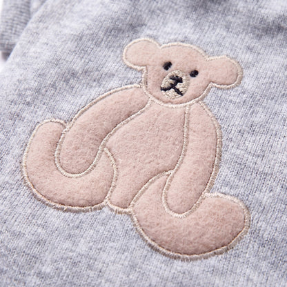 Gros plan sur l'ourson appliqué dans le dos du pull côtelé gris pour chien