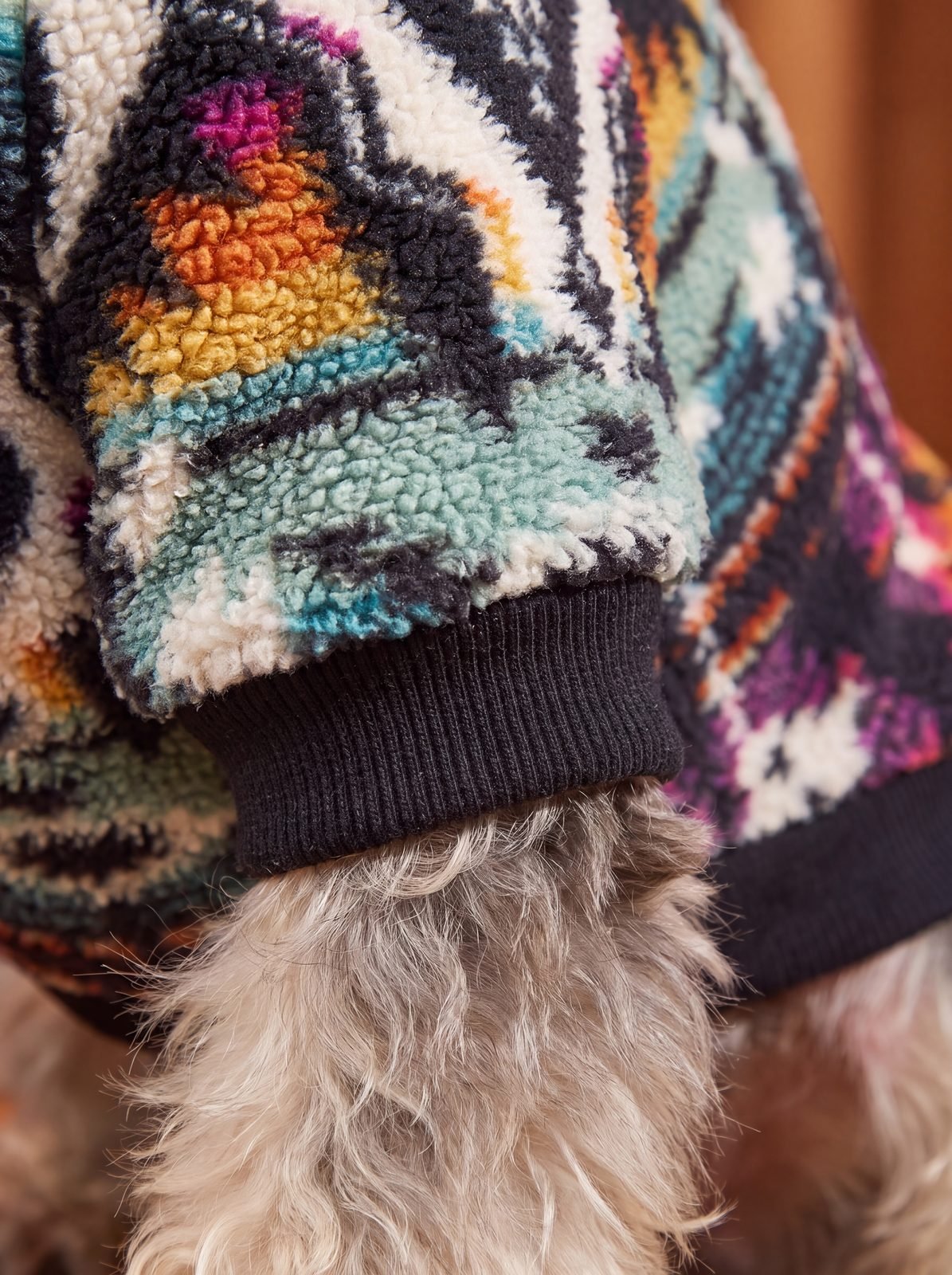 Gros plan sur le bord-côte noir de la manche du pull chien sherpa