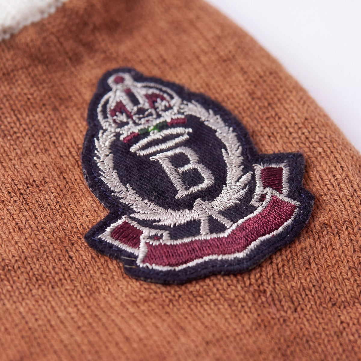 Gros plan sur l'écusson brodé du pull chien tricot marron