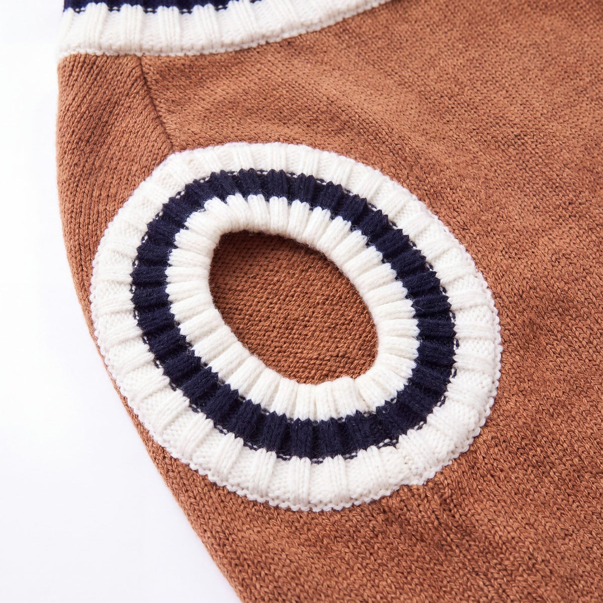 Gros plan sur l'emmanchure rayée crème et bleu marine du pull chien tricot marron