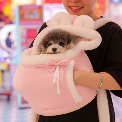 Sac a dos chien rose avec intérieur blanc petit chien noir porté sur le ventre.