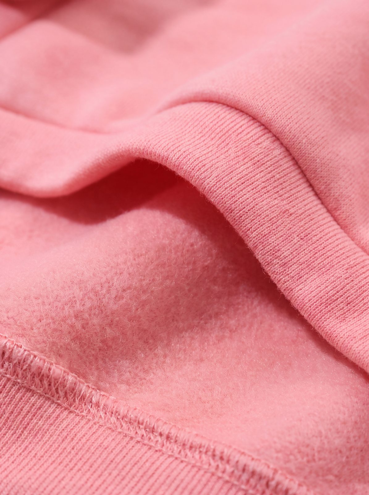 Macro de l'ourlet et de la doublure polaire du sweat à capuche chien rose