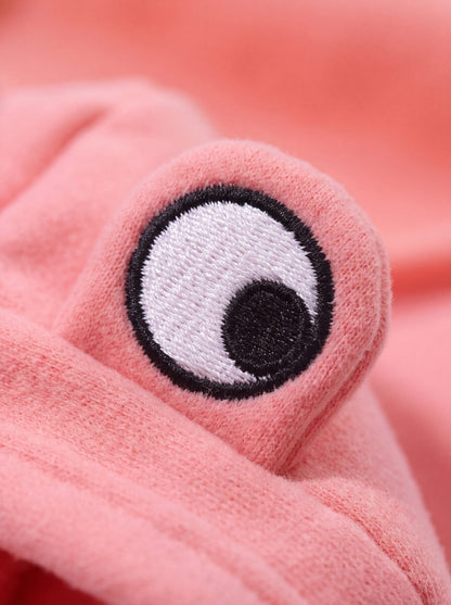Macro d'un œil brodé de la capuche grenouille du sweat chien rose