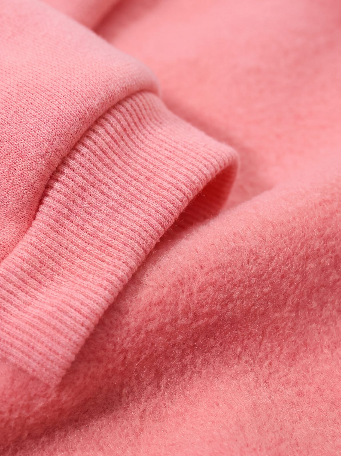 Macro du poignet côtelé et de la polaire du sweat à capuche chien rose