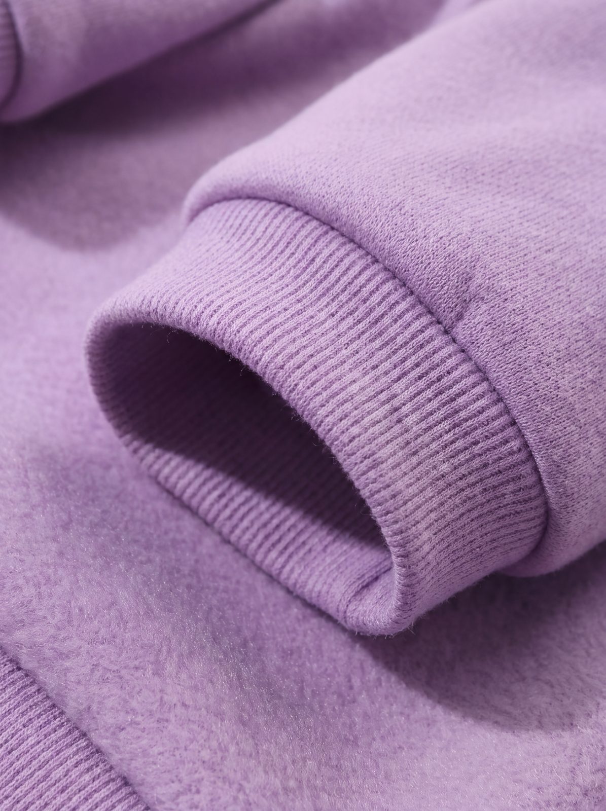 Gros plan sur le poignet côtelé du sweat à capuche grenouille violet