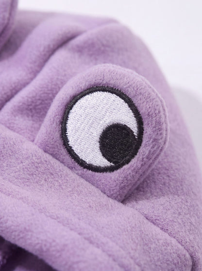 Gros plan sur l'œil brodé blanc de la capuche du sweat grenouille violet