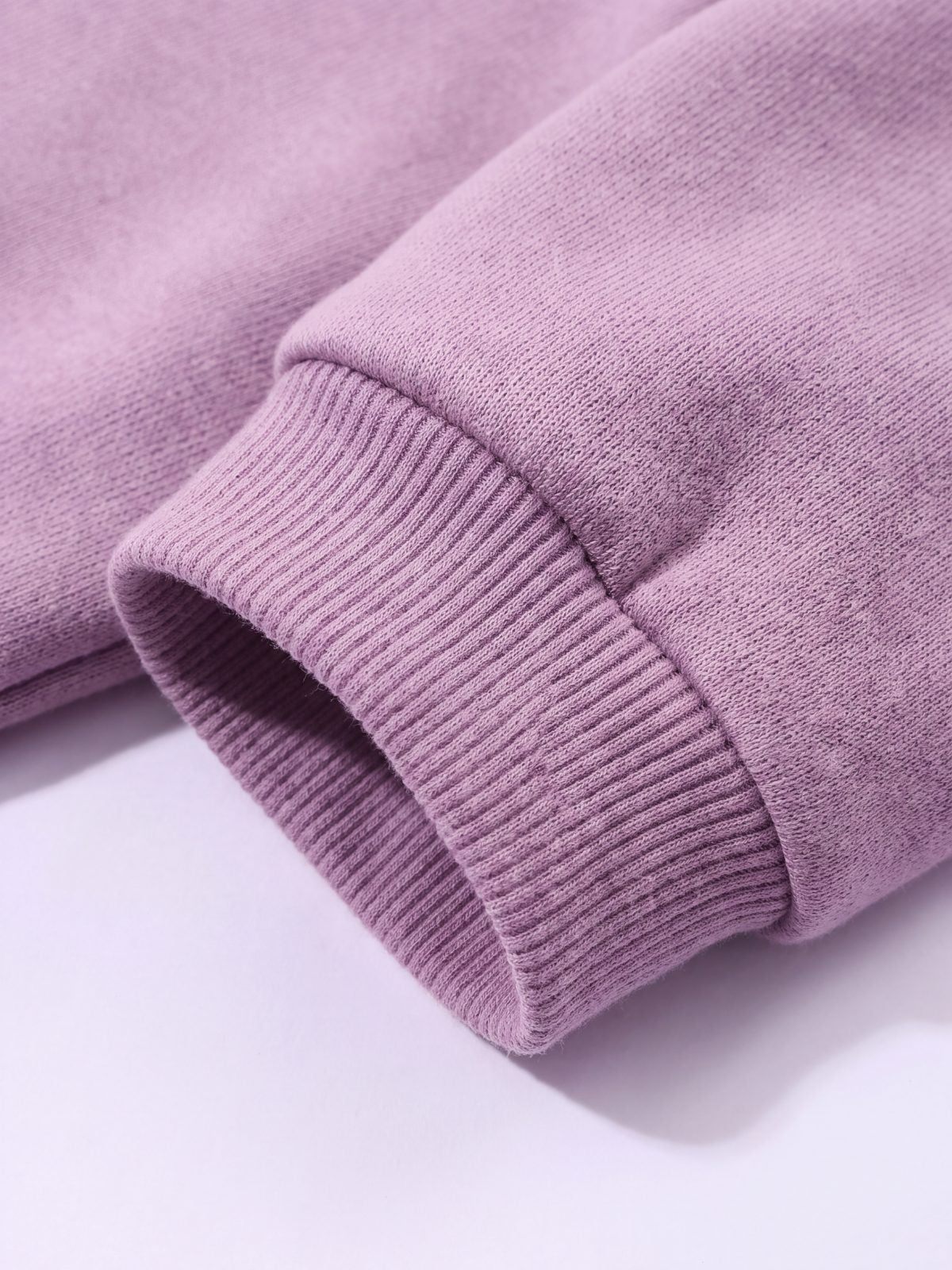 Gros plan sur le poignet côtelé du sweat à capuche chien mauve