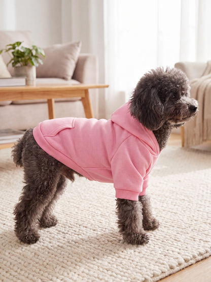Caniche de profil portant un sweat à capuche chien rose avec poche sur le dos