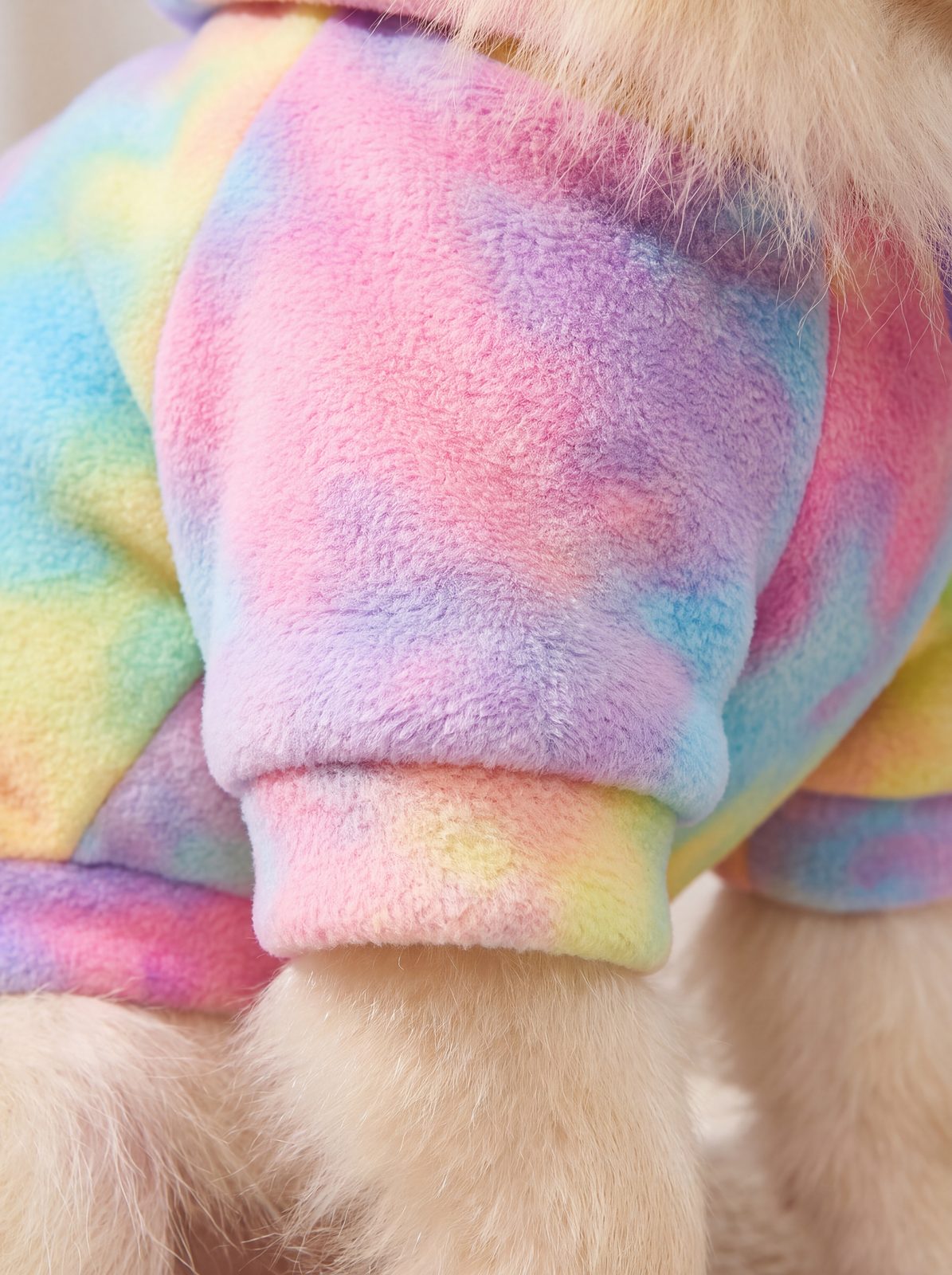 Gros plan sur la polaire douce et le poignet côtelé du sweat à capuche chien tie-dye